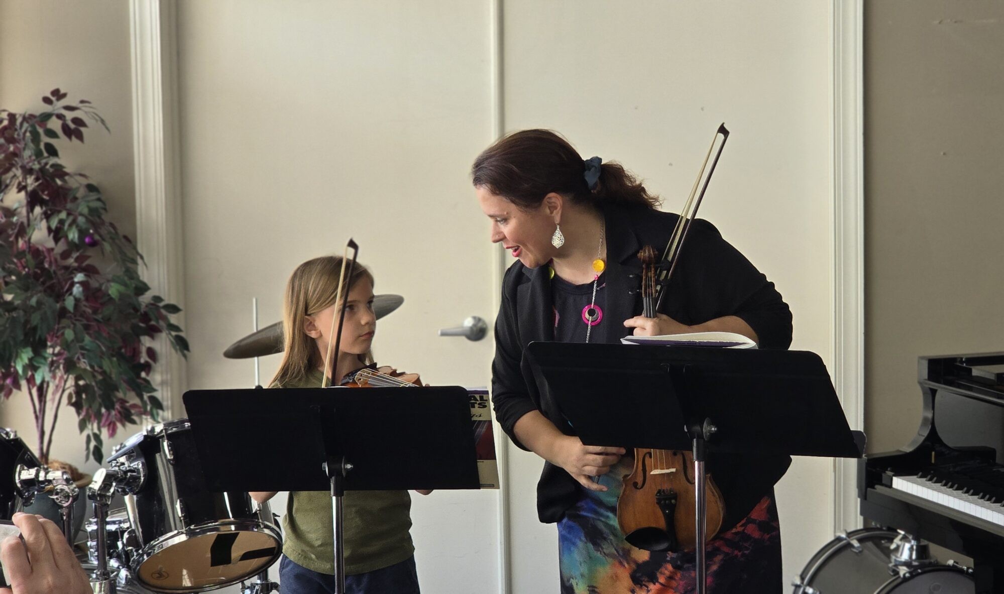 Teacher Emily and her student share an exchange before performing their violin duet.